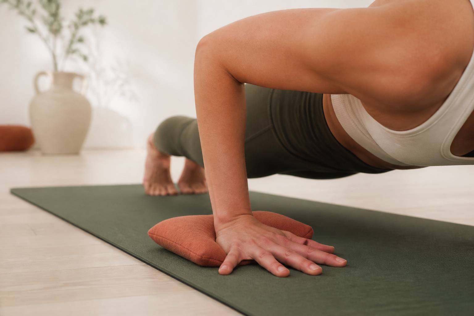 Mains et coudes alignés dans la posture Chaturanga sur un tapis