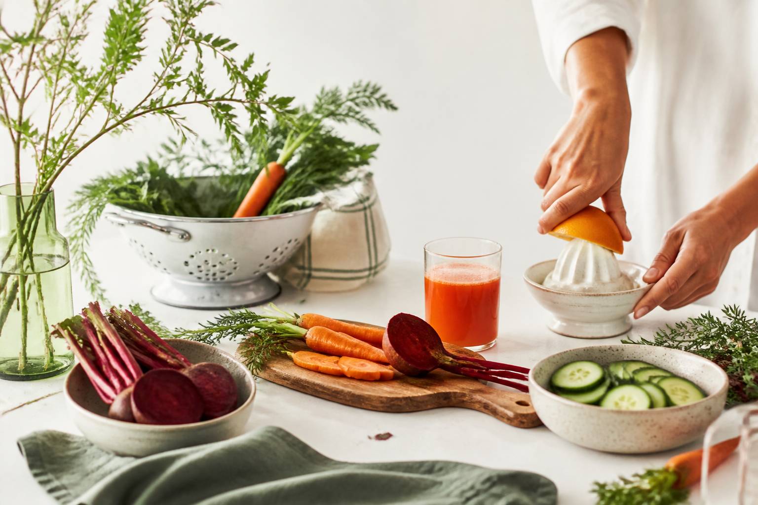 Légumes coupés et presse-agrumes sur un plan de travail clair